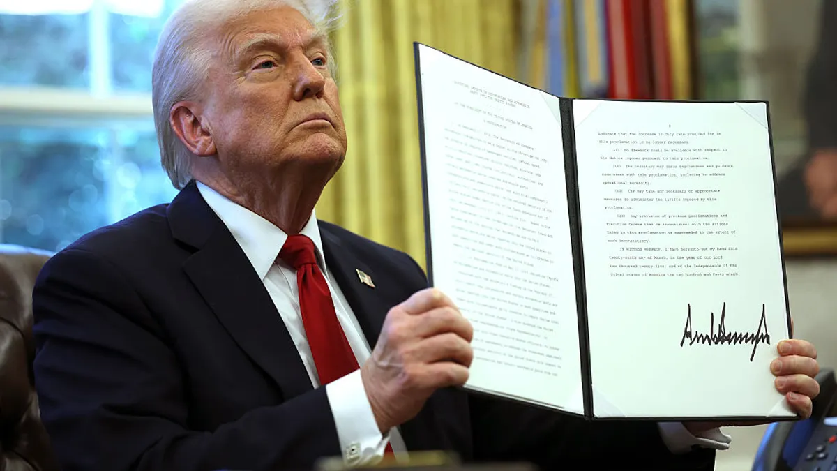 Trump holds a signed executive order in the Oval Office