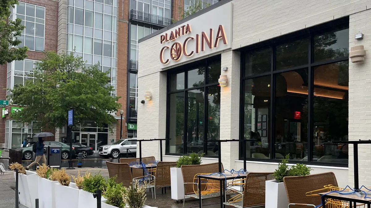 An exterior shot of a beige restaurant on a rainy day.