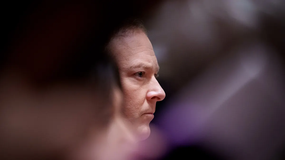 An image of a man's face appears amid a soft foreground and background.