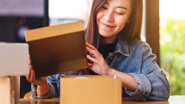Woman opening a brown box and smiling